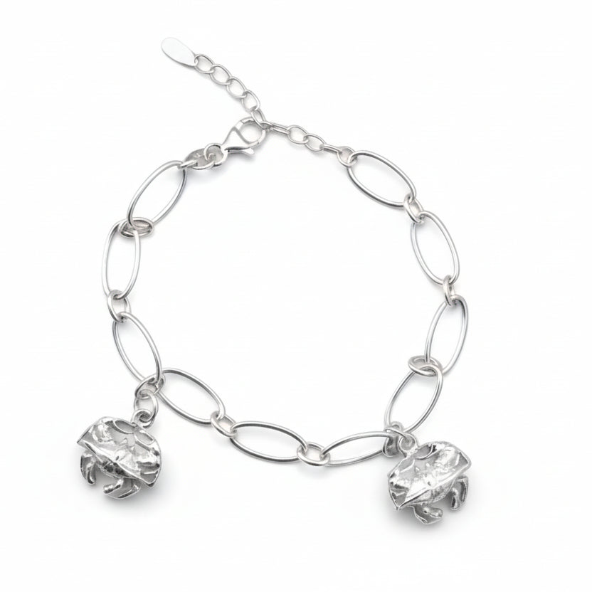 Silver chain bracelet with crab charms on a gray background