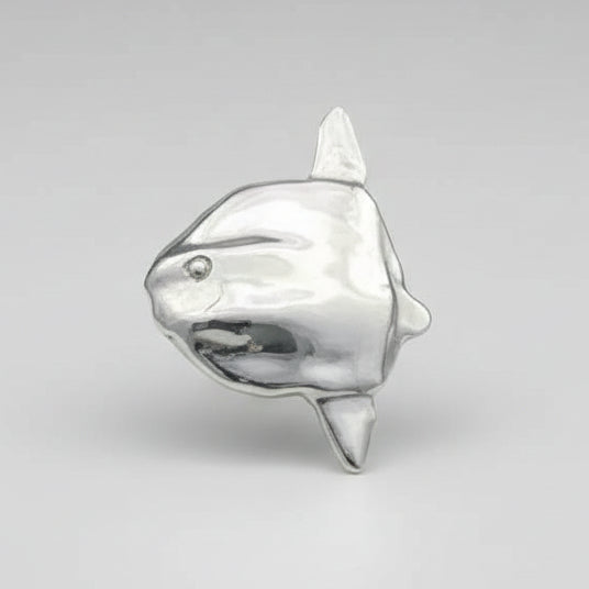 Silver mola mola-shaped charm on a light gray background