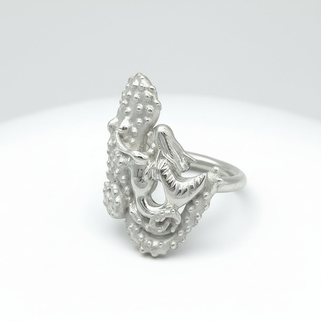 Silver octopus with mermaid ring with a detailed design on a light gray background