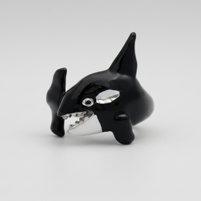 Black and silver orca whale figurine on a white background