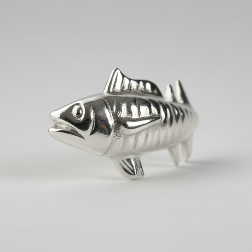 Silver fish-shaped object on a white background