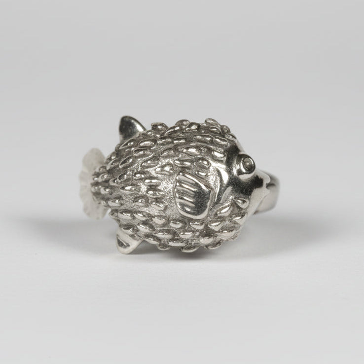 Silver puffer fish figurine on a white background