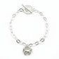 Silver bracelet with a toggle clasp on a light gray background