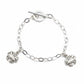 Silver chain bracelet with crab charms on a light gray background