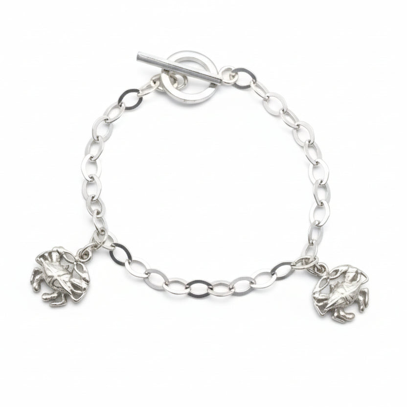 Silver chain bracelet with crab charms on a light gray background