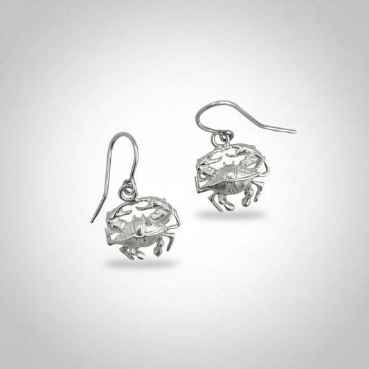 Pair of silver crab-shaped earrings on a light gray background
