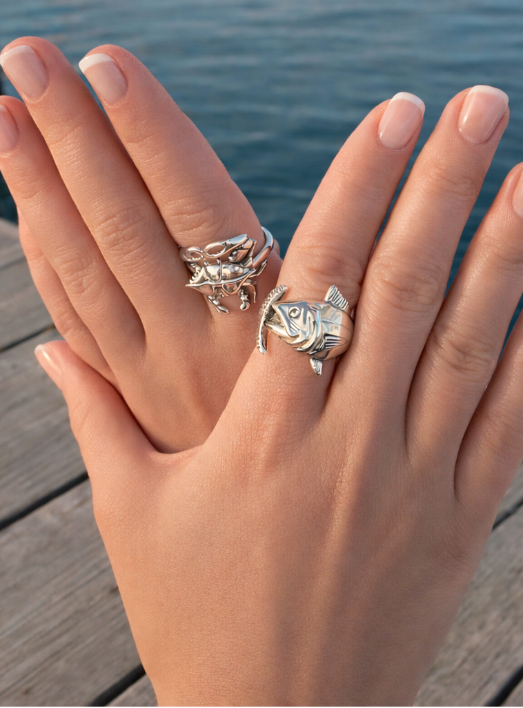 Hand wearing multiple silver rings with a blurred water background