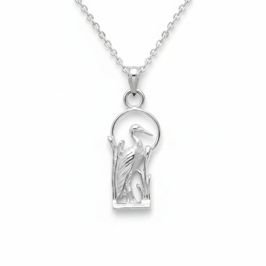 A sterling silver pendant featuring a detailed heron or crane figure inside a basket-like oval frame, shown against a neutral light gray textured background.