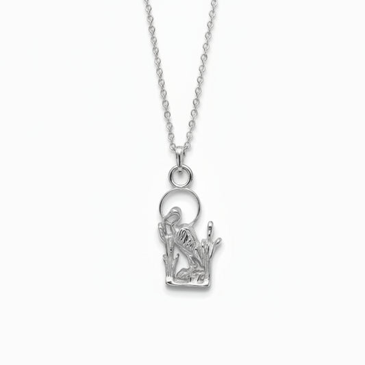A sterling silver pendant featuring a detailed cutout design of a heron standing among reeds, complete with a circular ring at the top for a chain.