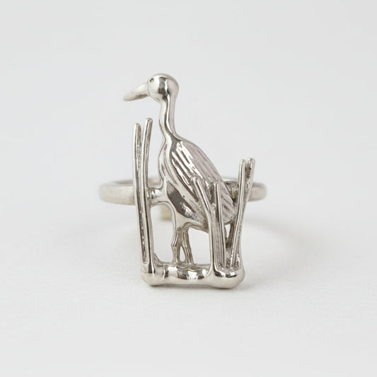 Silver heron ring on a light gray background