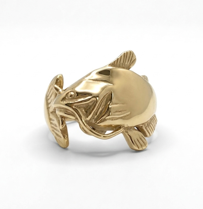 Gold catfish-shaped ring on a white background