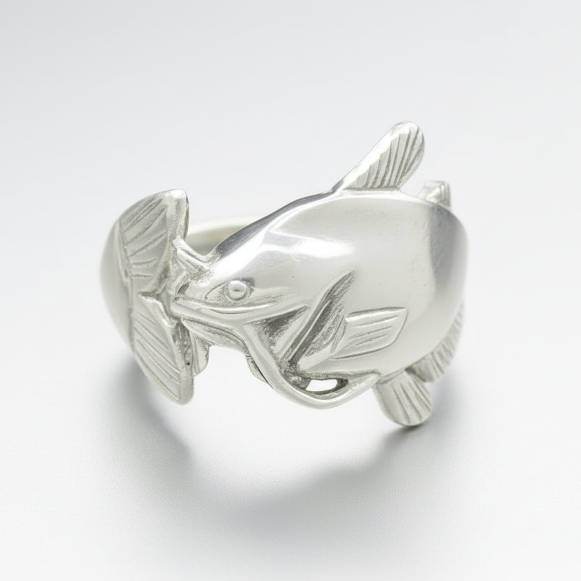 Silver fish-shaped ring on a gray background