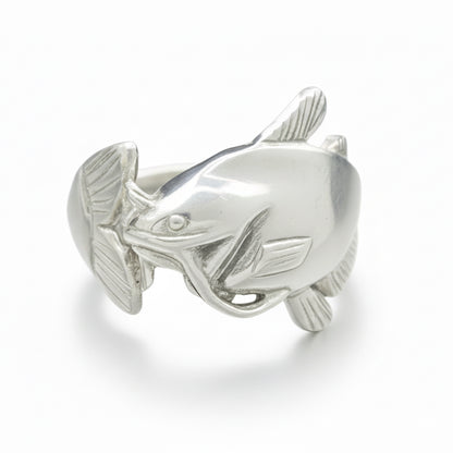 Silver fish-shaped ring on a gray background