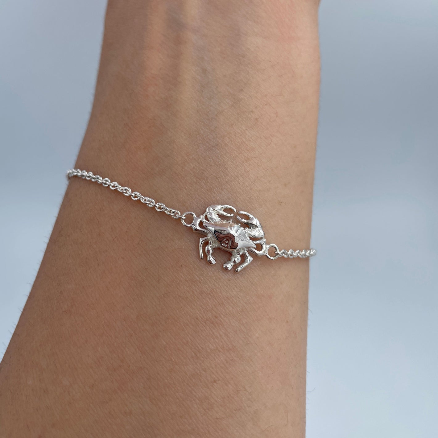 crab bracelet on model wrist in light gray background