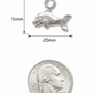 A small silver dolphin charm with a top loop, shown above a U.S. quarter coin for scale on a plain white background.