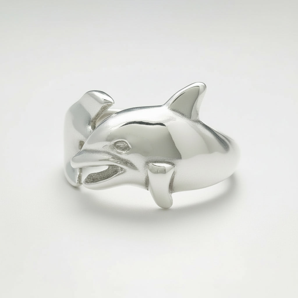 Silver dolphin-shaped ring on a light gray background