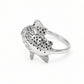 A sterling silver fish ring with detailed black spots and textured scales, shown on a whtie background.