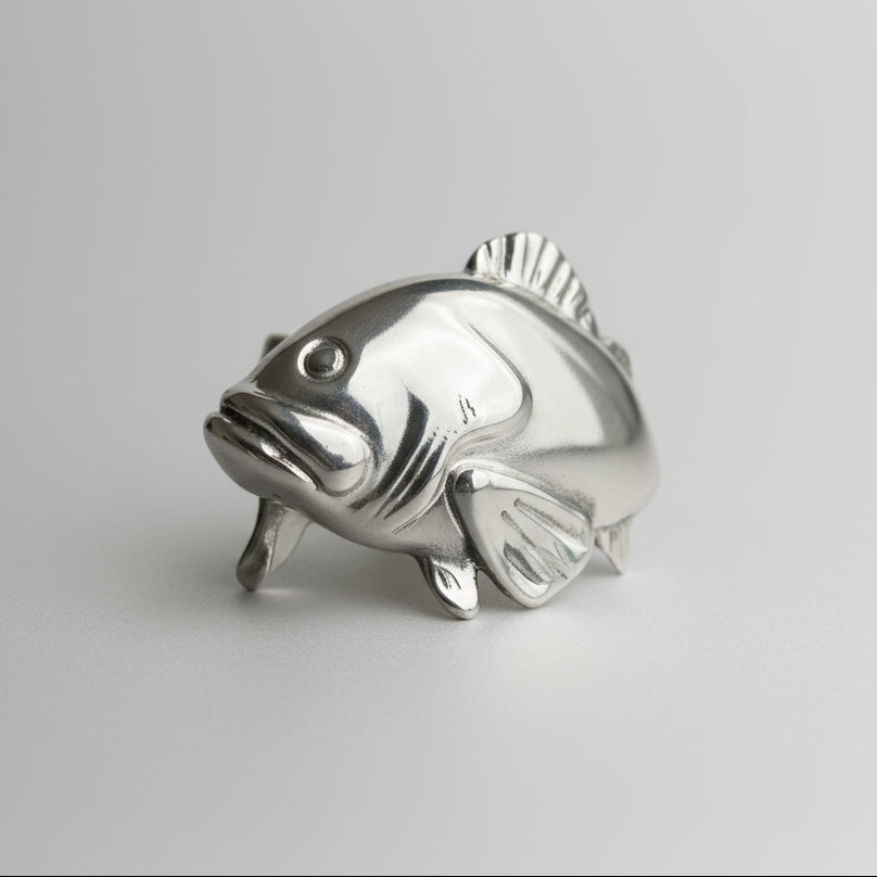 Silver fish-shaped object on a gray background
