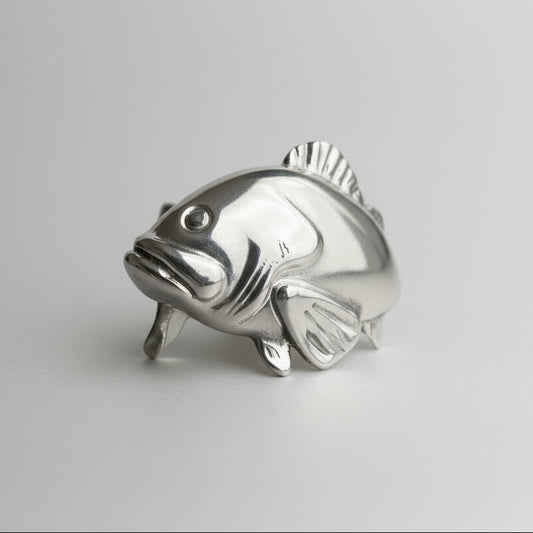 Silver fish-shaped object on a gray background