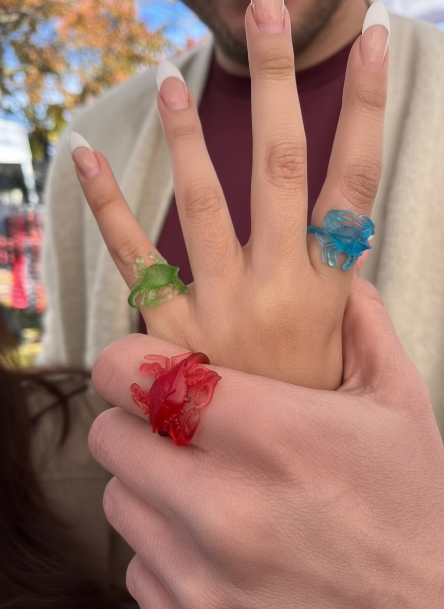 Close-up of a hand with colorful rings on fingers outdoors