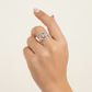 Hand wearing a silver ring on a light beige background