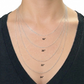Silver necklaces of different lengths displayed on a person wearing a black top.