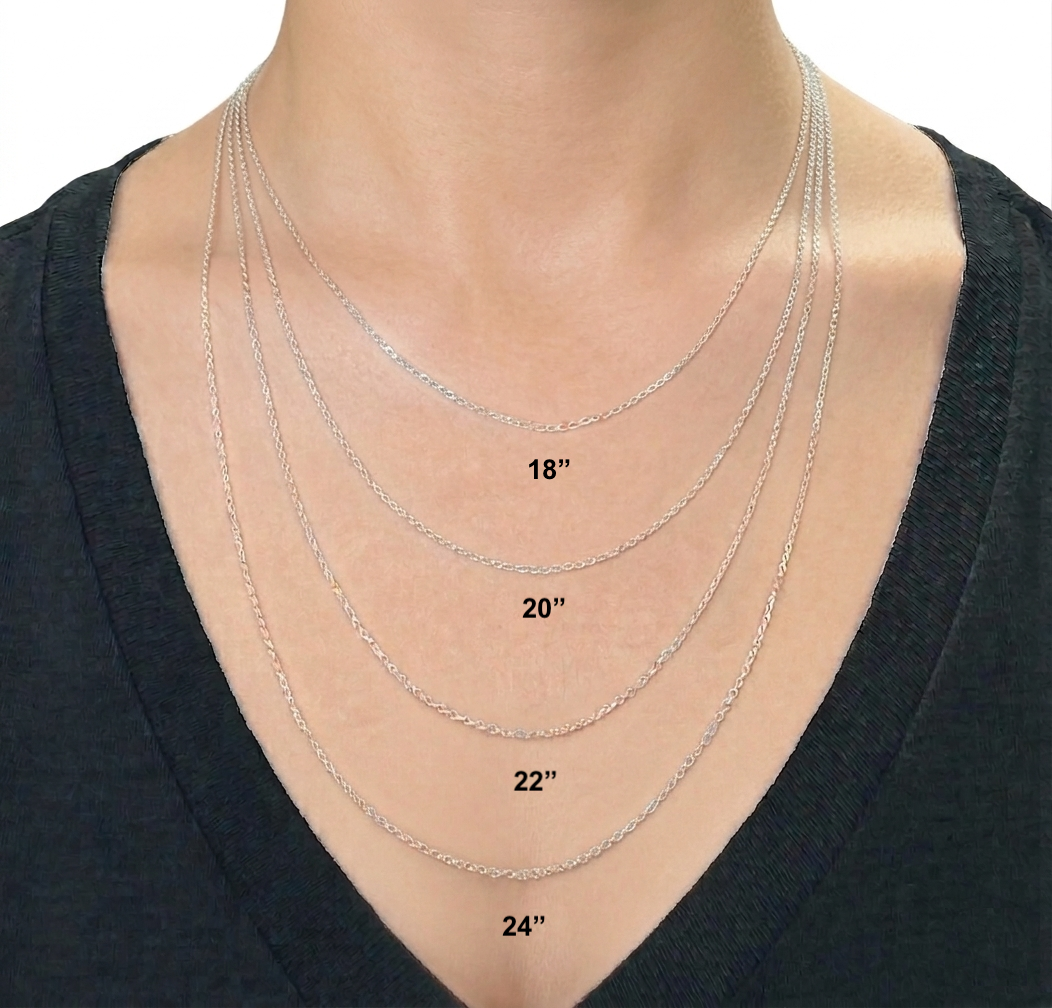Silver necklaces of different lengths displayed on a person wearing a black top.