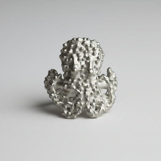 Silver octopus ring on a gray background