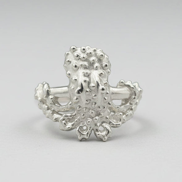 Silver octopus-shaped ring on a light gray background