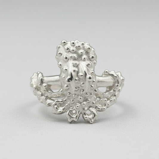 Silver octopus-shaped ring on a light gray background