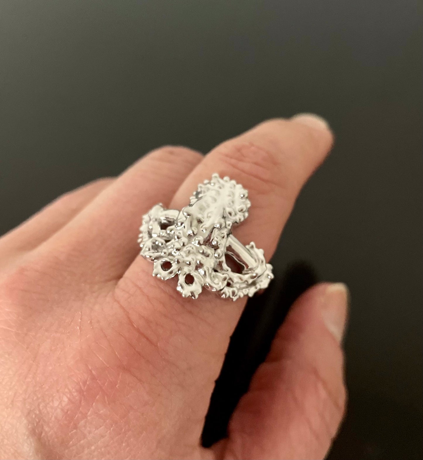 A silver ring with an octopus design, made of 925 solid silver brass and gold, with a polished band.