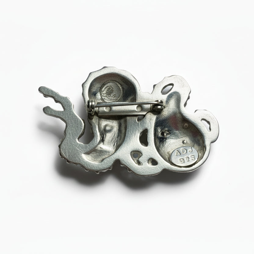 Silver octopus figurine charm on a plain background