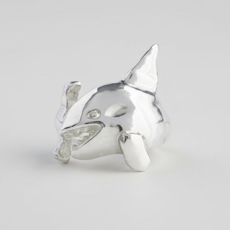 Silver shark-shaped ring on a light gray background