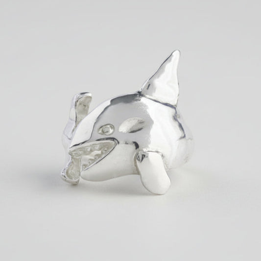 Silver shark-shaped ring on a light gray background