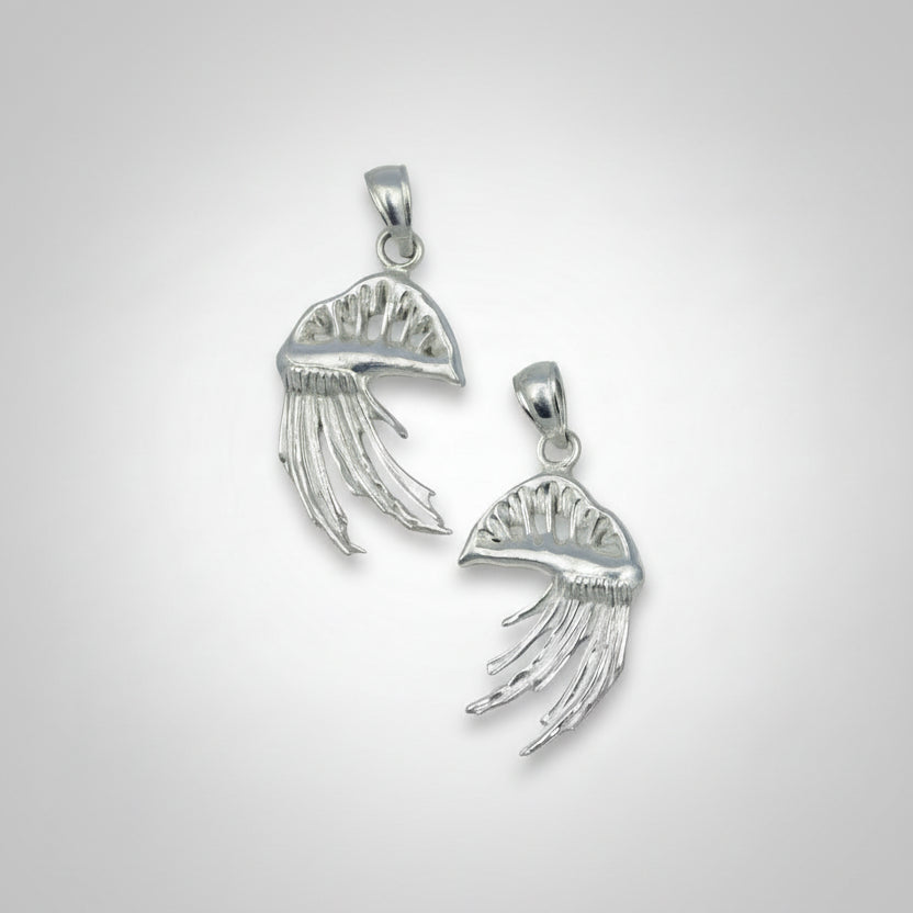 Two Portuguese Man O War-shaped pendants on a gray background