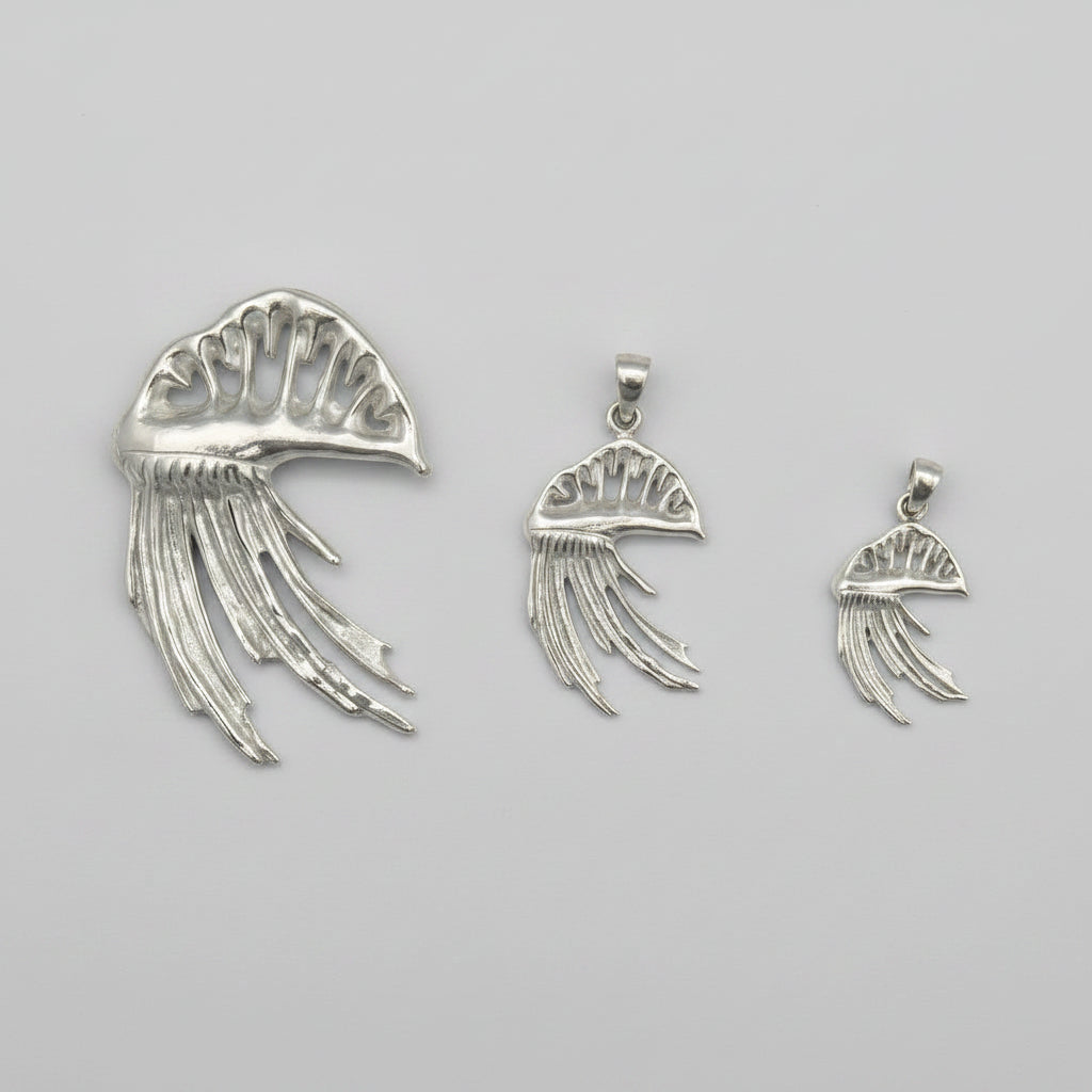 Set of silver jellyfish-shaped pendants on a gray background