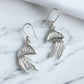 Silver Man o war earrings on white marble