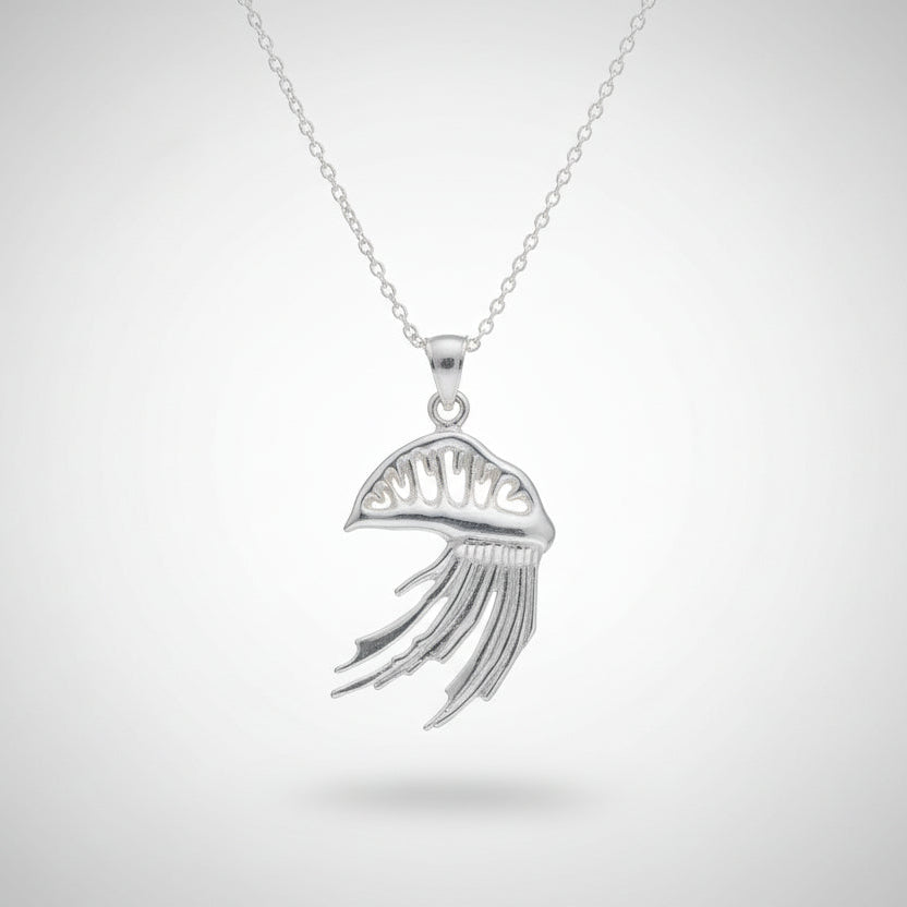 Silver man o' war  pendants on chains held in a hand against a neutral background