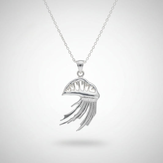 Silver man o' war  pendants on chains held in a hand against a neutral background