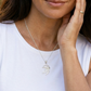 Woman wearing a silver necklace with a Portuguese man o war  pendant on a white background