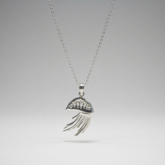 Silver Portuguese man o war necklace with a decorative pendant on a white surface