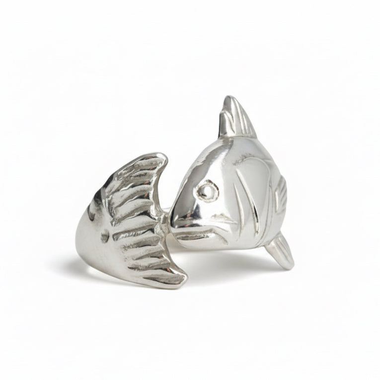 Silver fish-shaped object on a light gray background