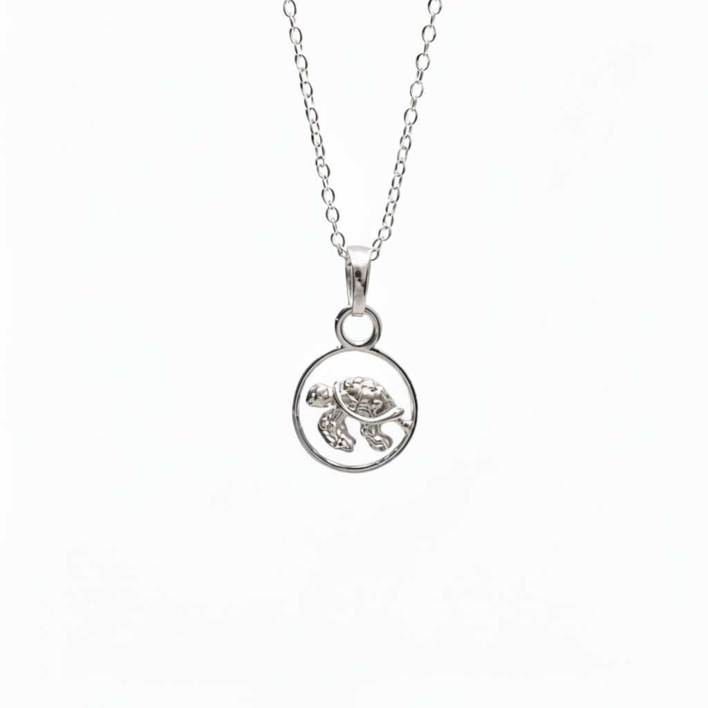 A silver necklace featuring a circular pendant with a small sea turtle design, shown against a plain white background.