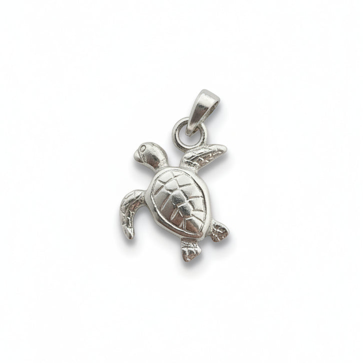 A small silver sea turtle pendant charm with a textured shell and a loop at the top, shown on a plain light gray surface.