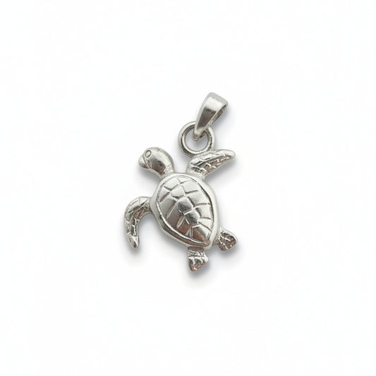 A small silver sea turtle pendant charm with a textured shell and a loop at the top, shown on a plain light gray surface.