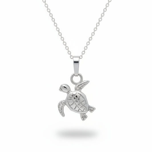 A silver sea turtle pendant necklace on a matching silver chain, displayed against a textured light gray background.