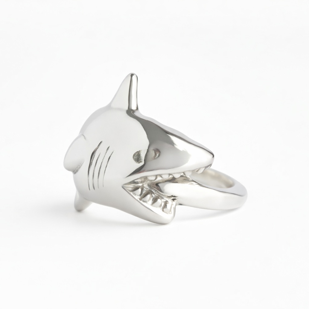 Silver shark-shaped ring on a white background
