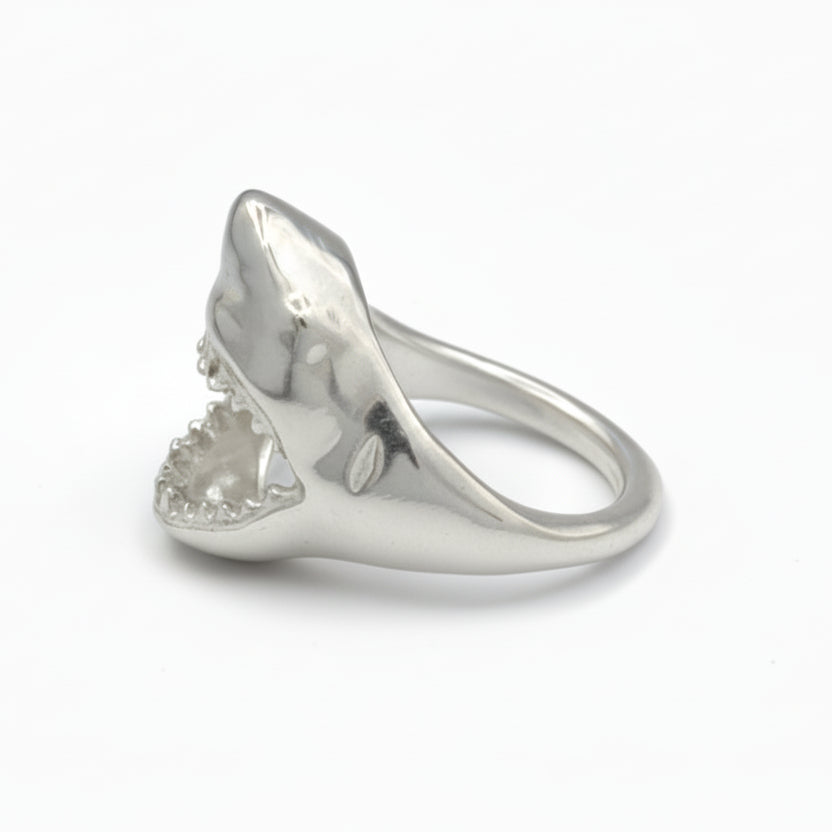 Silver ring with a shark tooth design on a gray background