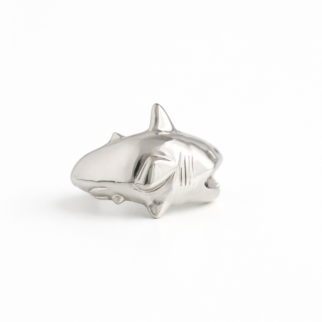 Silver shark-shaped ring on a white background