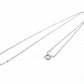 Silver necklace on a light gray background